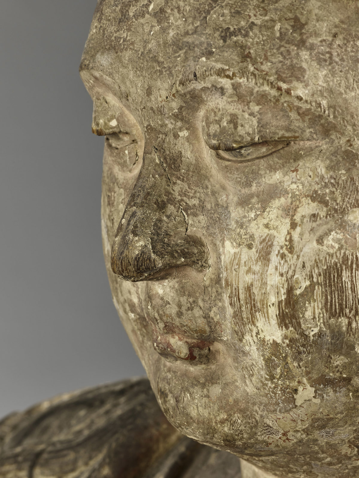 Close up of the face of a wooden statue of Guanyin.