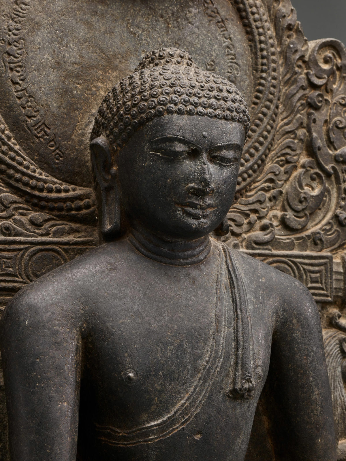 Detail view of the Buddha's head and shoulders.