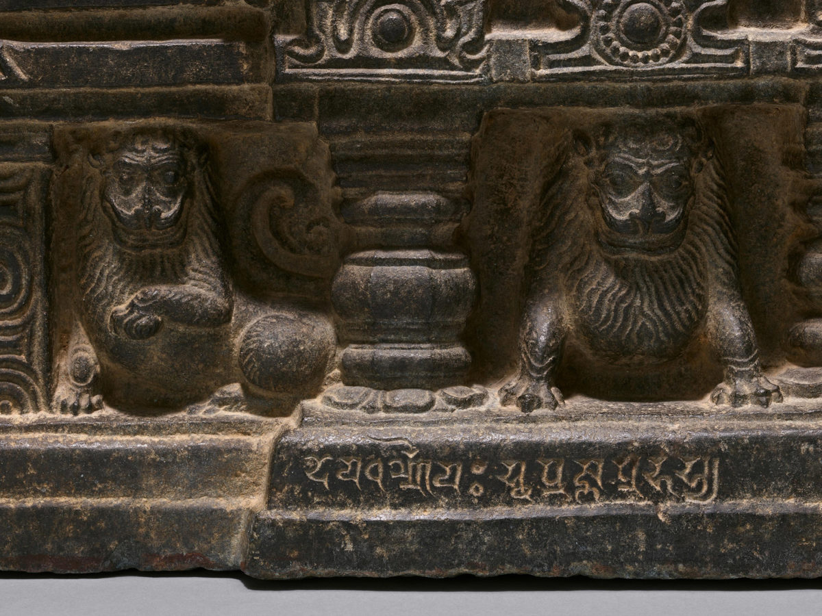 Detailed view of lions standing beneath the platform the Buddha sits on.