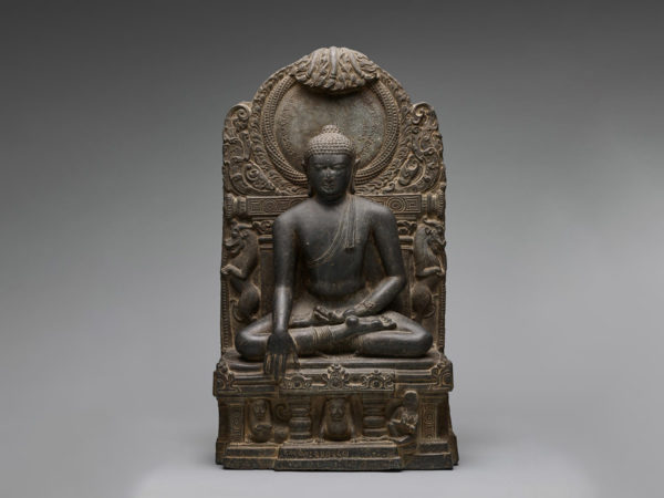 Front view of a carved figure of a seated Buddha.