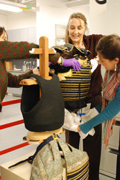 Conservators work on a suit of Japanese armor.